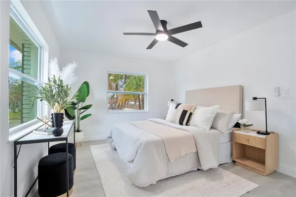 a bedroom with a bed and a potted plant