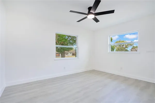 an empty room with wooden floor and window