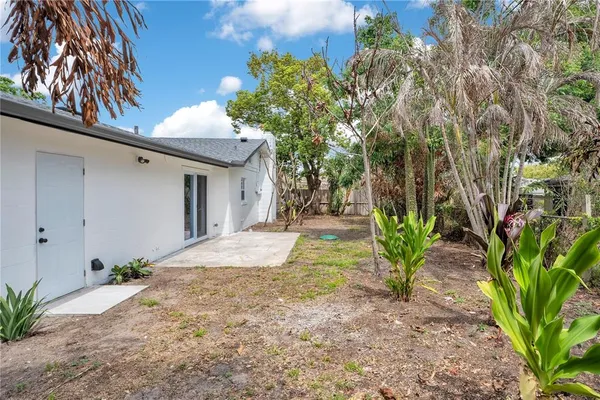 a pathway of a house with a yard and potted plants