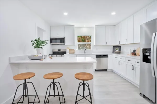 a kitchen with cabinets a sink and white appliances