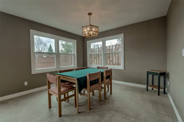a dining room with a wooden table and chairs