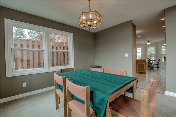 a view of a dining room with furniture a chandelier and wooden floor