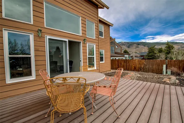 a view of a patio with table and chairs with wooden floor and fence