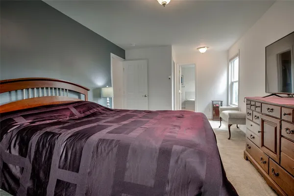 a bed sitting in a bedroom next to a window
