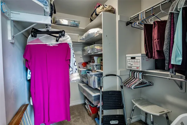 a view of walk in closet with clothes and shoes