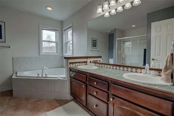 a bathroom with a tub double sink and mirror