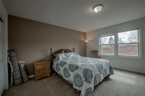 a bed sitting in a bedroom next to a window