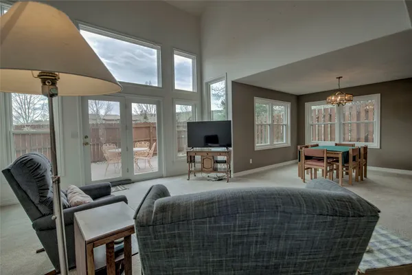 a bedroom with a bed and large windows