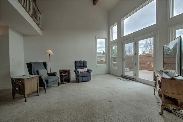 a living room with furniture a flat screen tv and a window