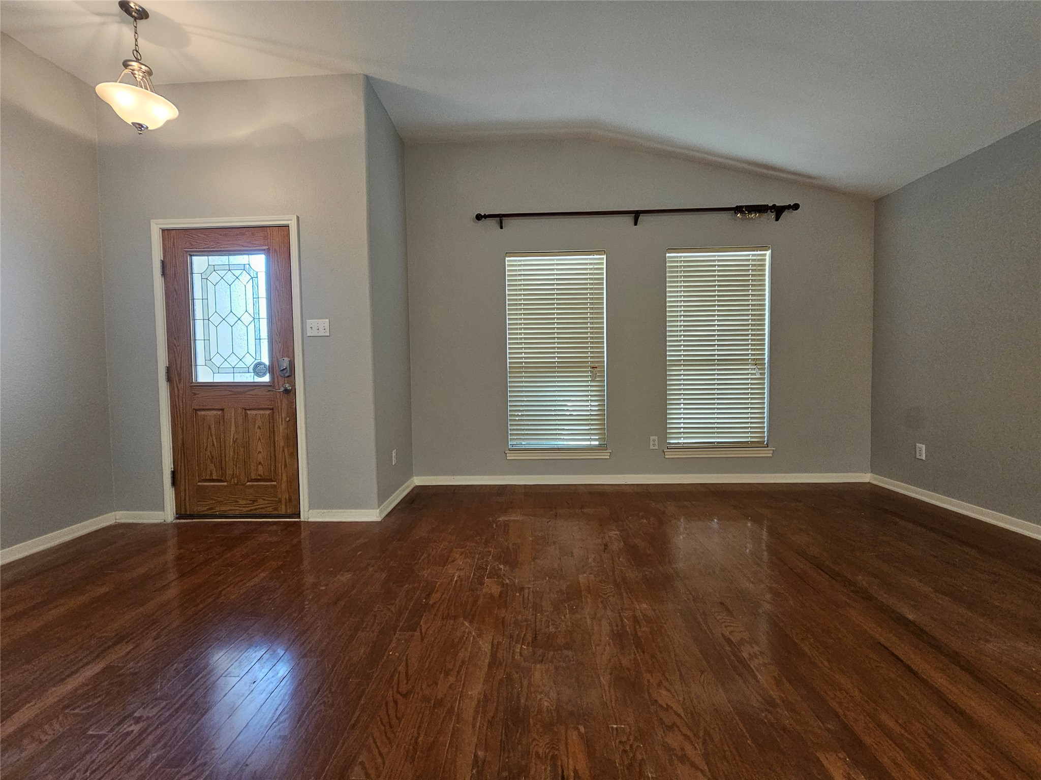2035 Intrepid Drive Buda, TX 78610 - Photo 2 of 26 Rich hardwood floors welcome you into this generously proportioned living area with vaulted ceilings.