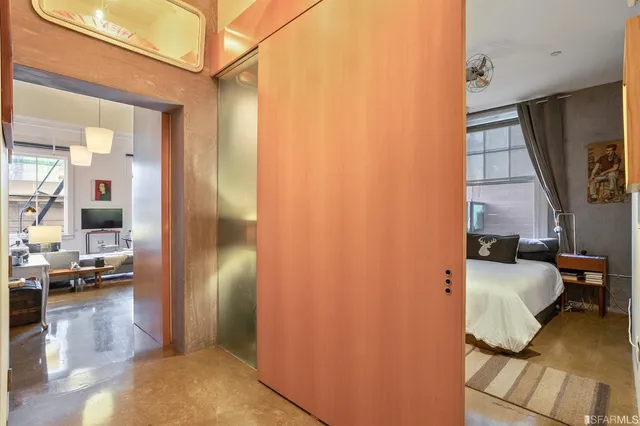 a bedroom with a bed and wooden floor