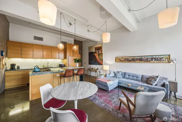a living room with furniture kitchen view and a large window