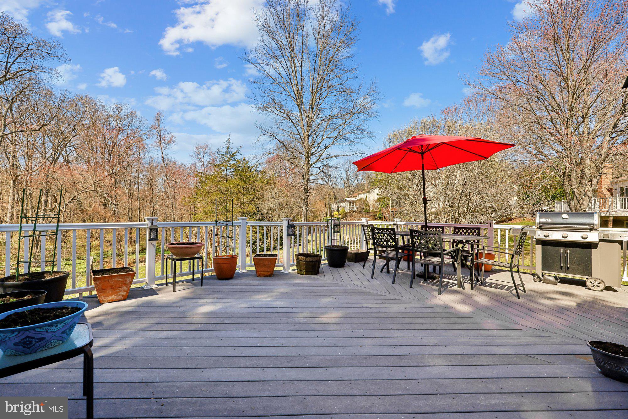 18 Kaywood Court Silver Spring, MD 20905 - Photo 35 of 71 a view of a rooftop deck with dining table and chairs under an umbrella