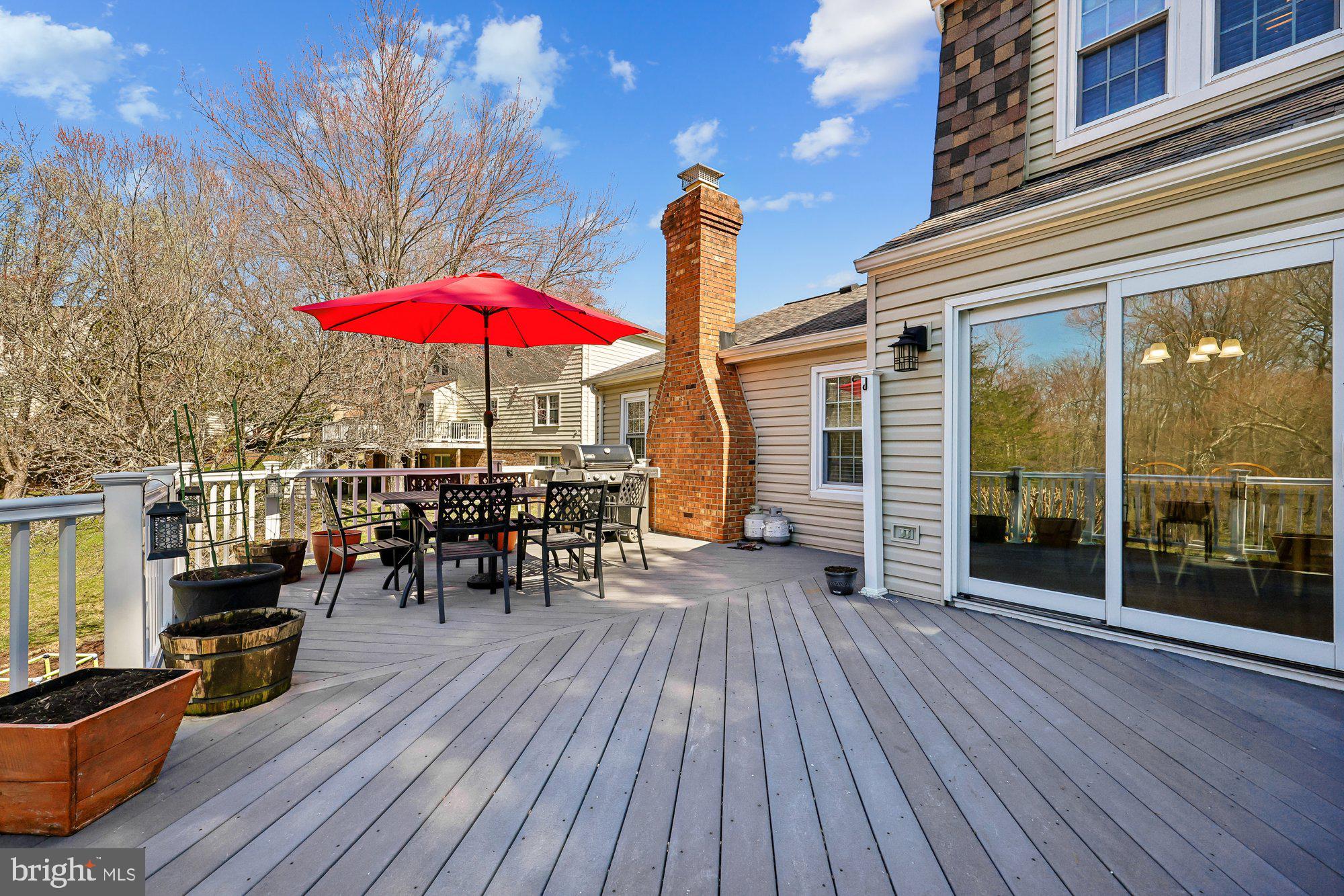 18 Kaywood Court Silver Spring, MD 20905 - Photo 36 of 71 a view of a patio with table and chairs under an umbrella with wooden floor