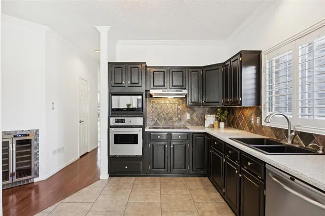 a kitchen with stainless steel appliances granite countertop a sink and dishwasher a stove top oven with wooden floor