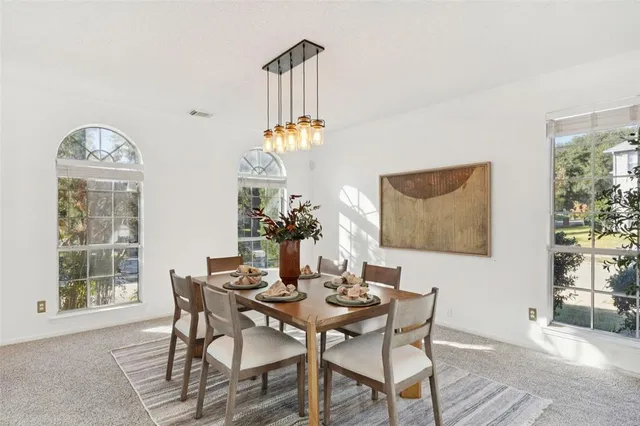 a view of a dining room with furniture and a chandelier