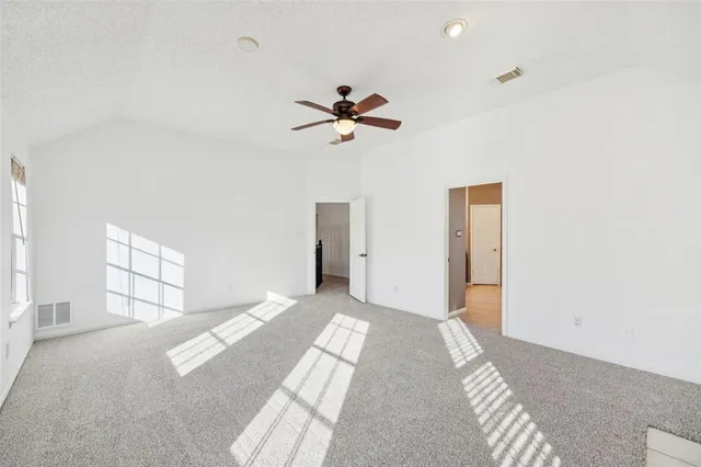 a view of a bedroom with a ceiling fan and window