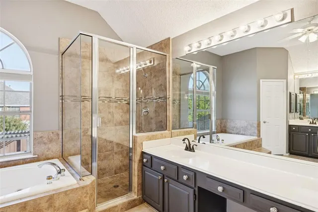 a bathroom with a granite countertop sink mirror and a bathtub