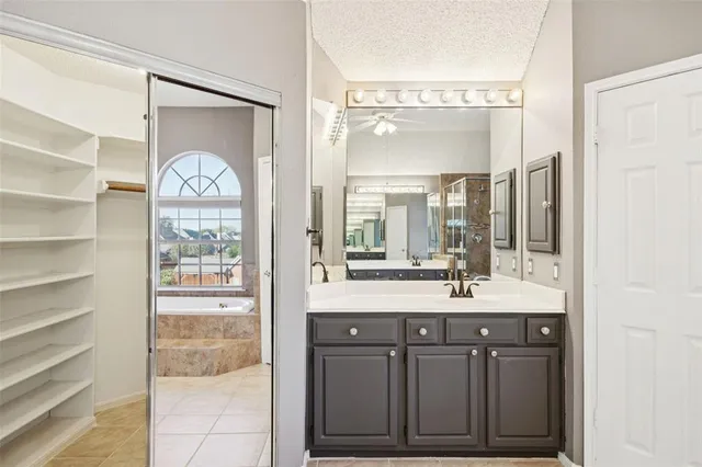 a bathroom with a sink mirror and a shower