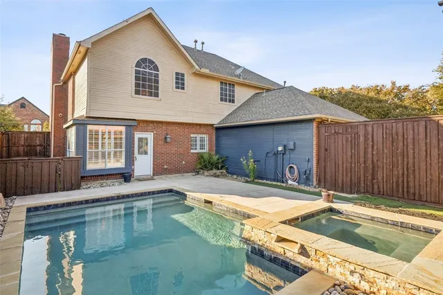 a view of a backyard with wooden fence and a glass door