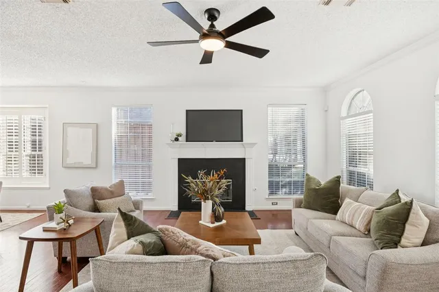 a living room with furniture a fireplace and a large window