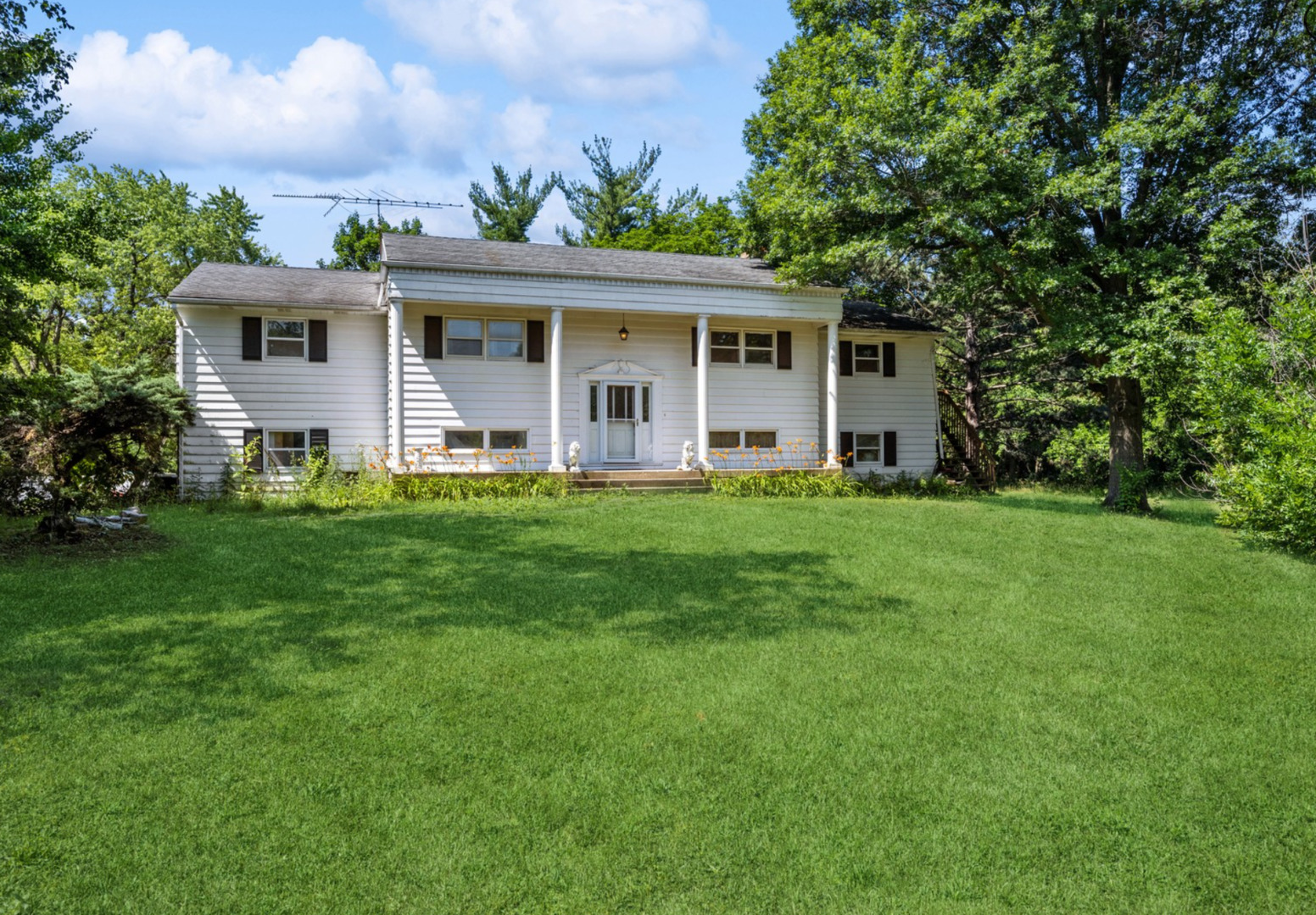 a front view of a house with a yard and trees