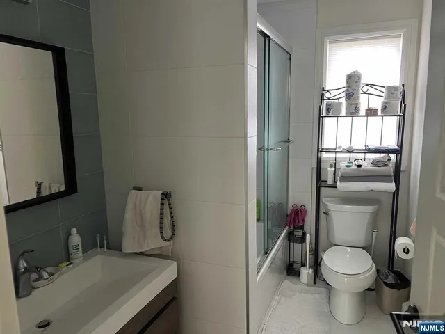 a bathroom with a toilet sink and mirror