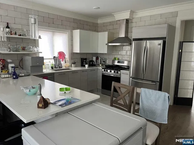 a kitchen with stainless steel appliances granite countertop a sink refrigerator and cabinets