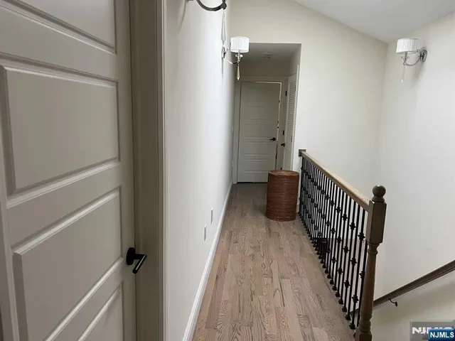 a view of a hallway with wooden floor and staircase