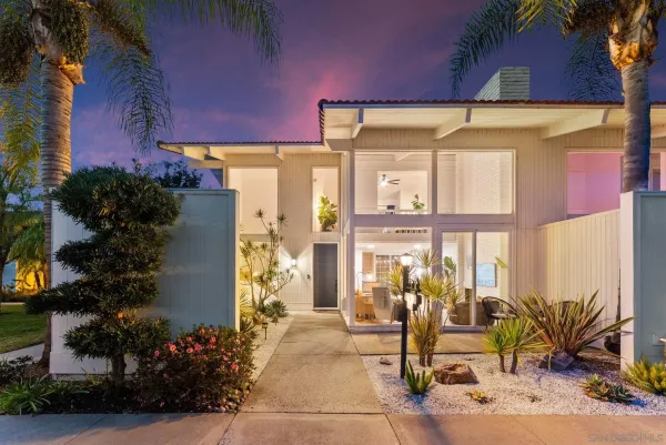 a front view of a house with outdoor seating and a potted plant