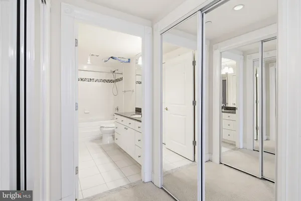 a bathroom with a granite countertop shower mirror and toilet
