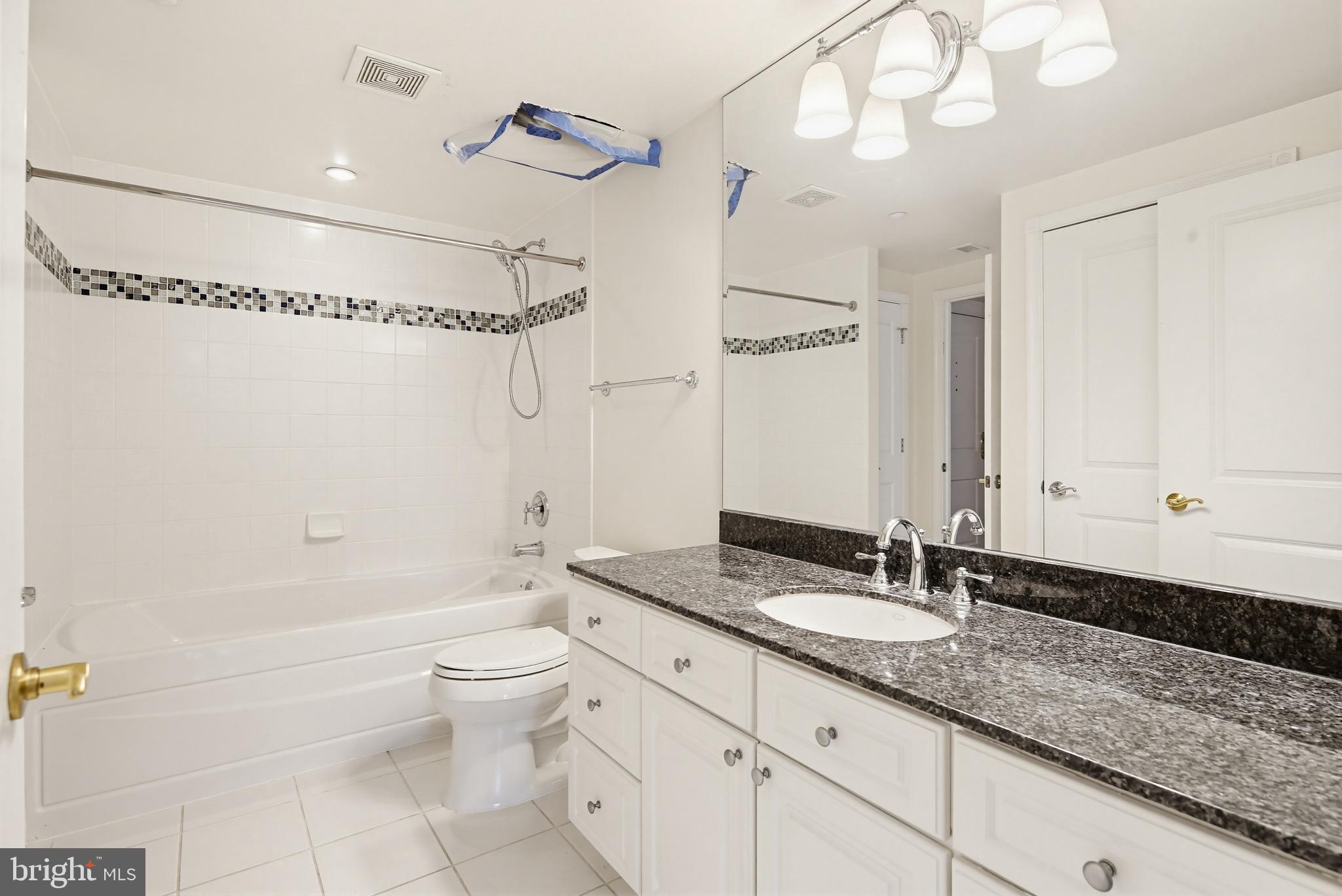 5 Park Place, Unit 425 Annapolis, MD 21401 - Photo 14 of 28 a bathroom with a granite countertop sink a toilet a mirror and shower