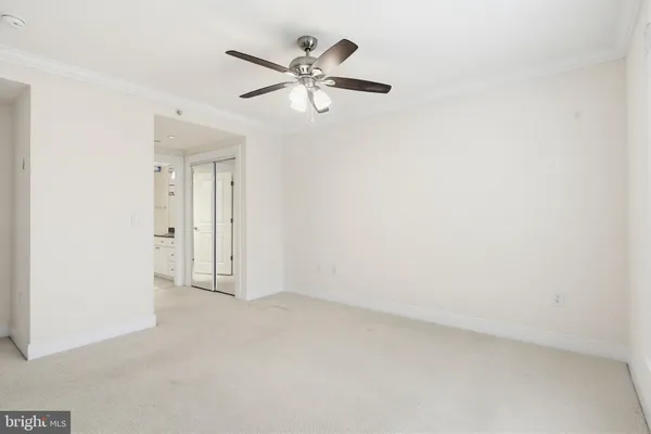 an empty room with closet and windows
