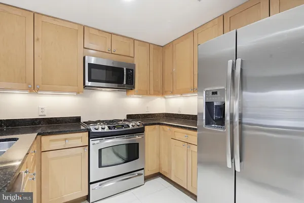 a kitchen with cabinets stainless steel appliances and a counter space