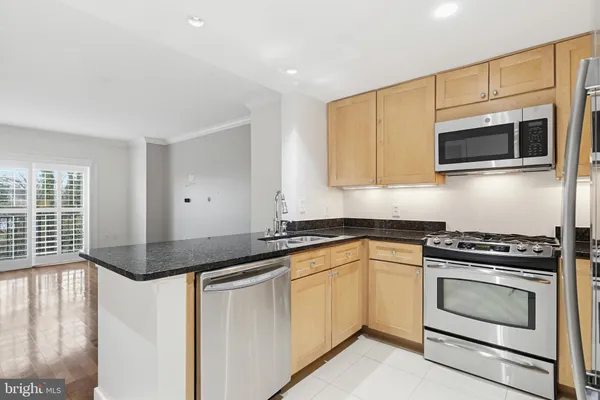 a kitchen with granite countertop a stove sink and microwave
