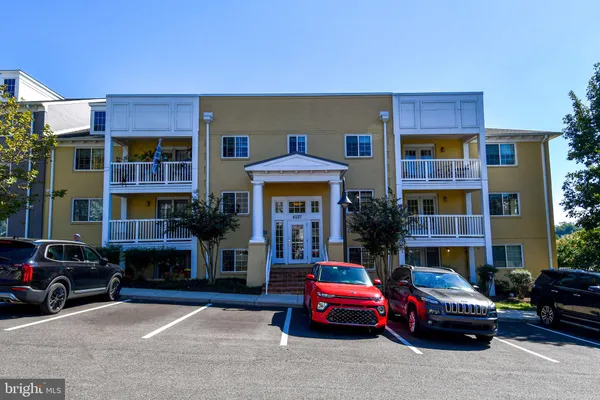 a front view of building with cars parked