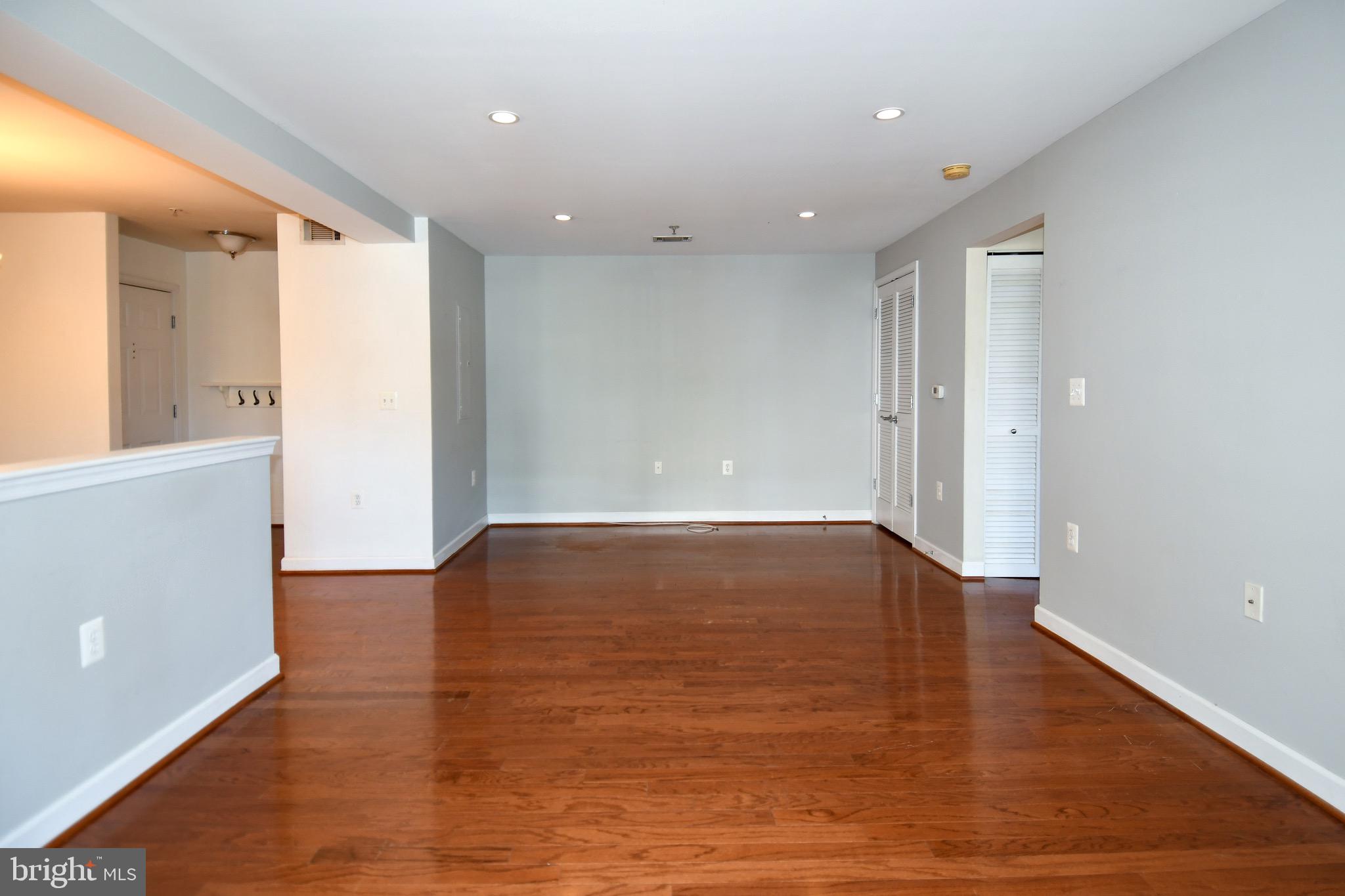 4127 South Four Mile Run Drive, Unit 304 Arlington, VA 22204 - Photo 20 of 44 a view of an empty room with wooden floor and a window