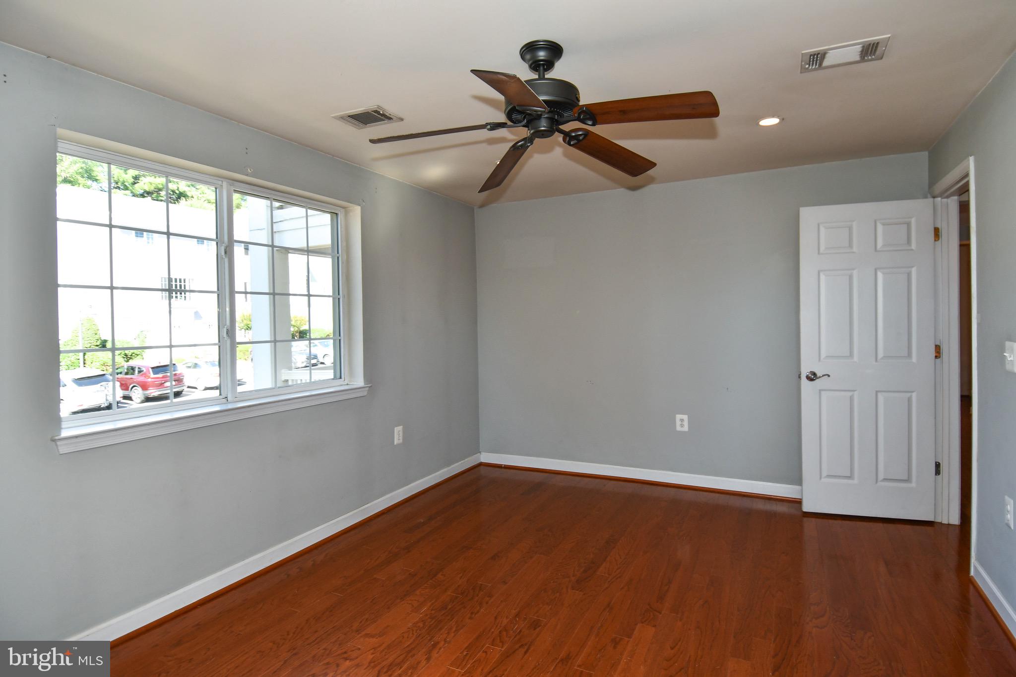 4127 South Four Mile Run Drive, Unit 304 Arlington, VA 22204 - Photo 24 of 44 a view of an empty room with wooden floor and a window