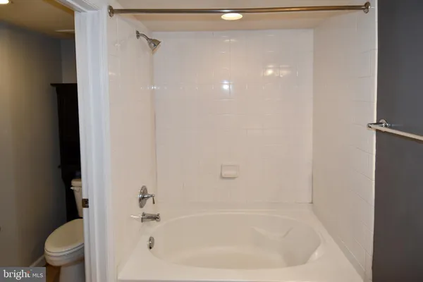 a white bath tub sitting next to a toilet