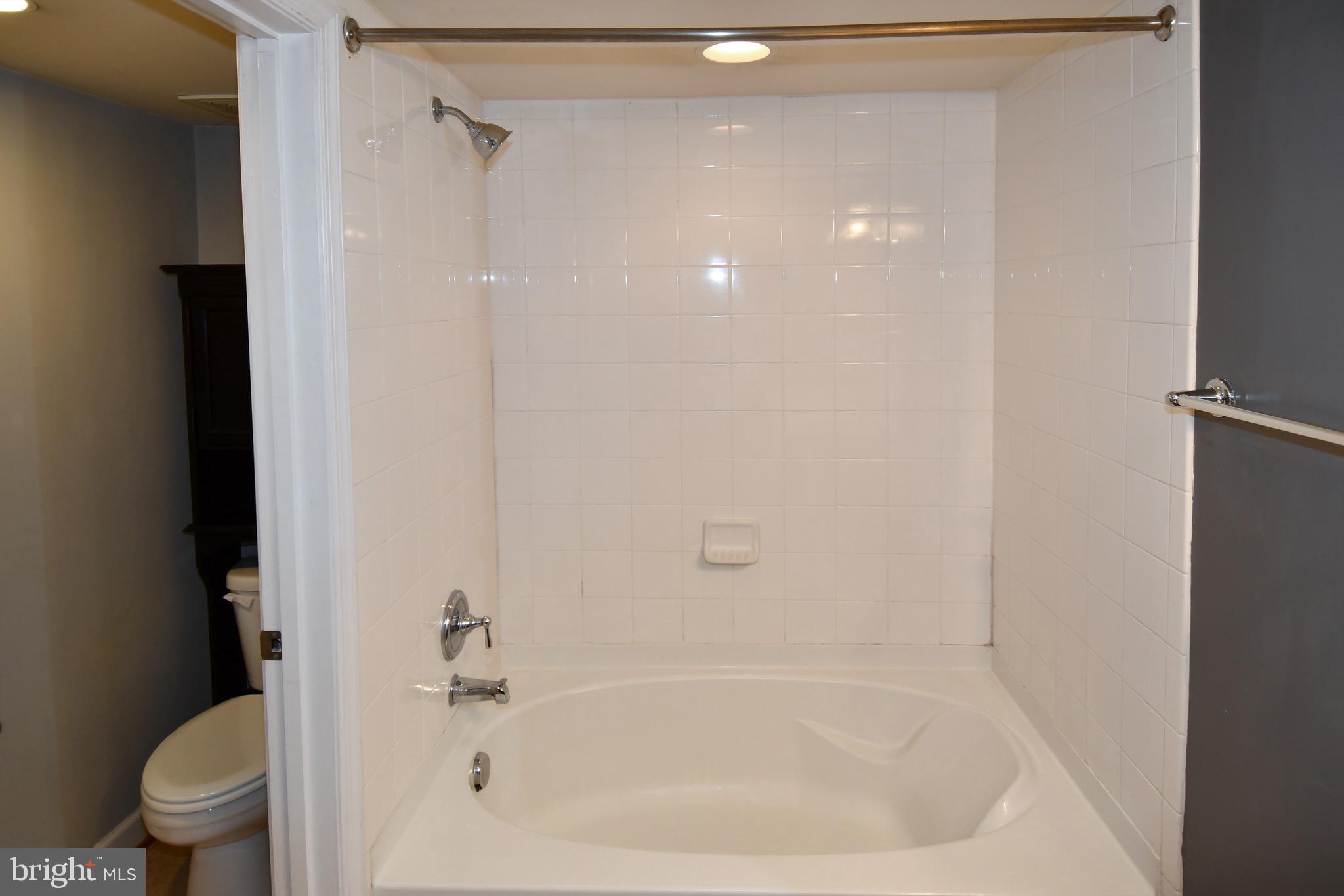 4127 South Four Mile Run Drive, Unit 304 Arlington, VA 22204 - Photo 27 of 44 a white bath tub sitting next to a toilet