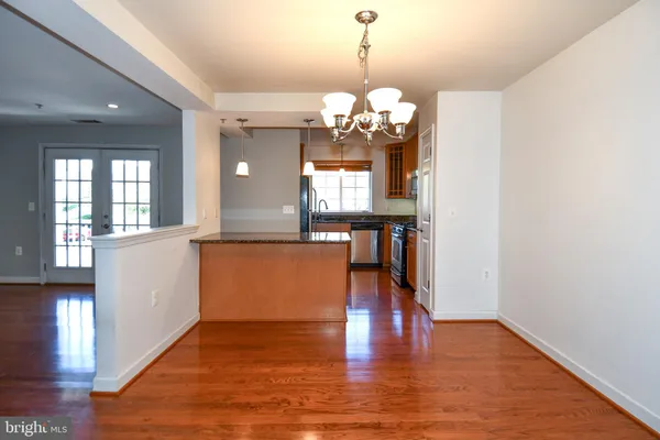 a view of a room with wooden floor and kitchen