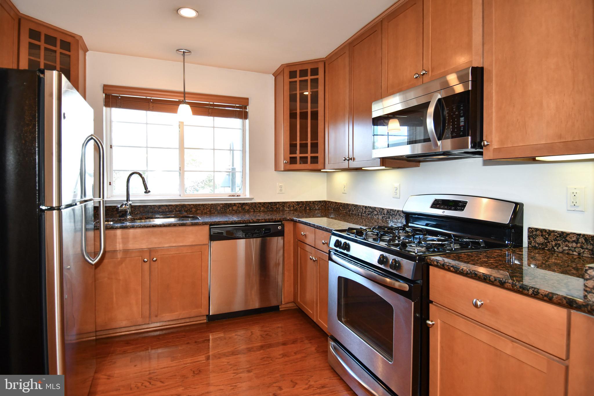 4127 South Four Mile Run Drive, Unit 304 Arlington, VA 22204 - Photo 8 of 44 a kitchen with stainless steel appliances granite countertop a refrigerator a stove a sink and a microwave