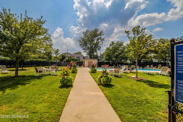 a view of swimming pool with lawn chairs and a big yard