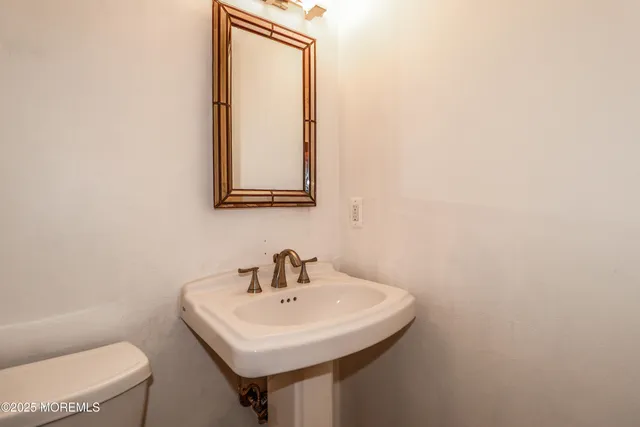 a bathroom with a sink a toilet and mirror