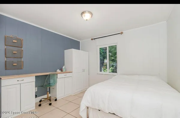 a bedroom with a bed and a large window