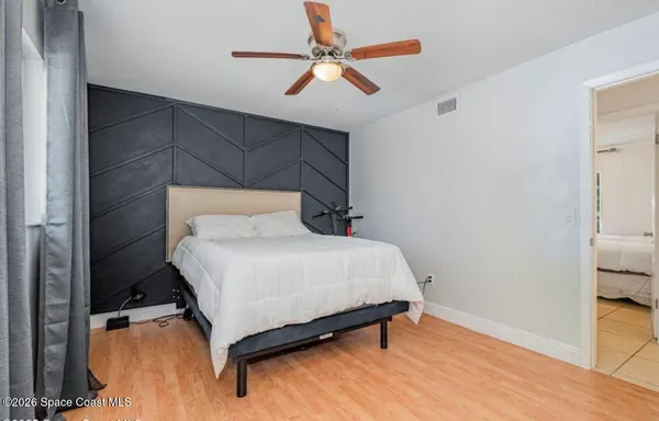 a bedroom with a bed and a ceiling fan
