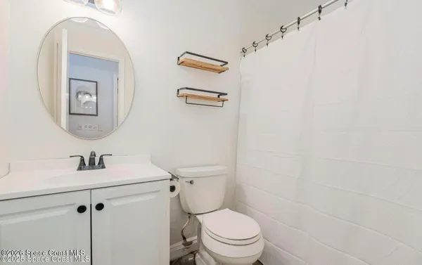 a bathroom with a sink mirror vanity and toilet