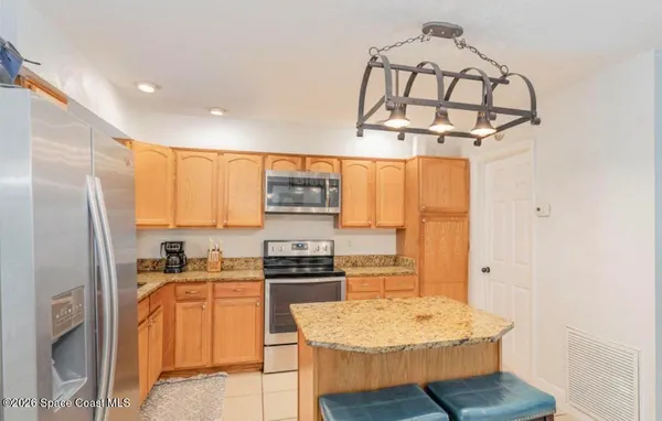 a kitchen with stainless steel appliances a refrigerator a stove a sink dishwasher and white cabinets with wooden floor