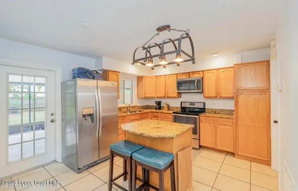 a kitchen with stainless steel appliances granite countertop a refrigerator a stove and a sink