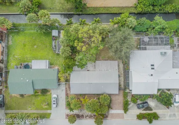 an aerial view of a house with a yard and lake view